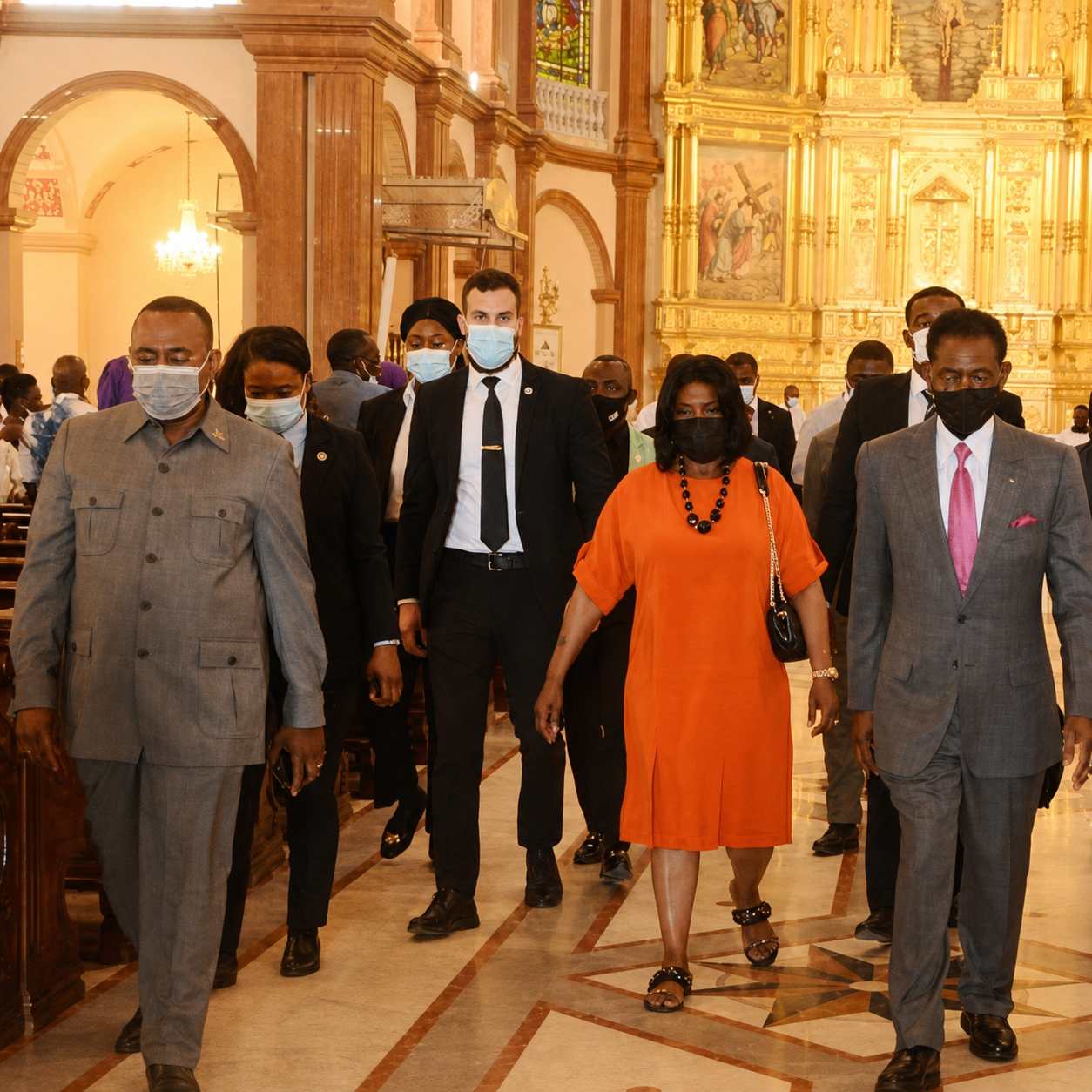Close protection detail escorting an official delegation through a ceremonial venue in Africa